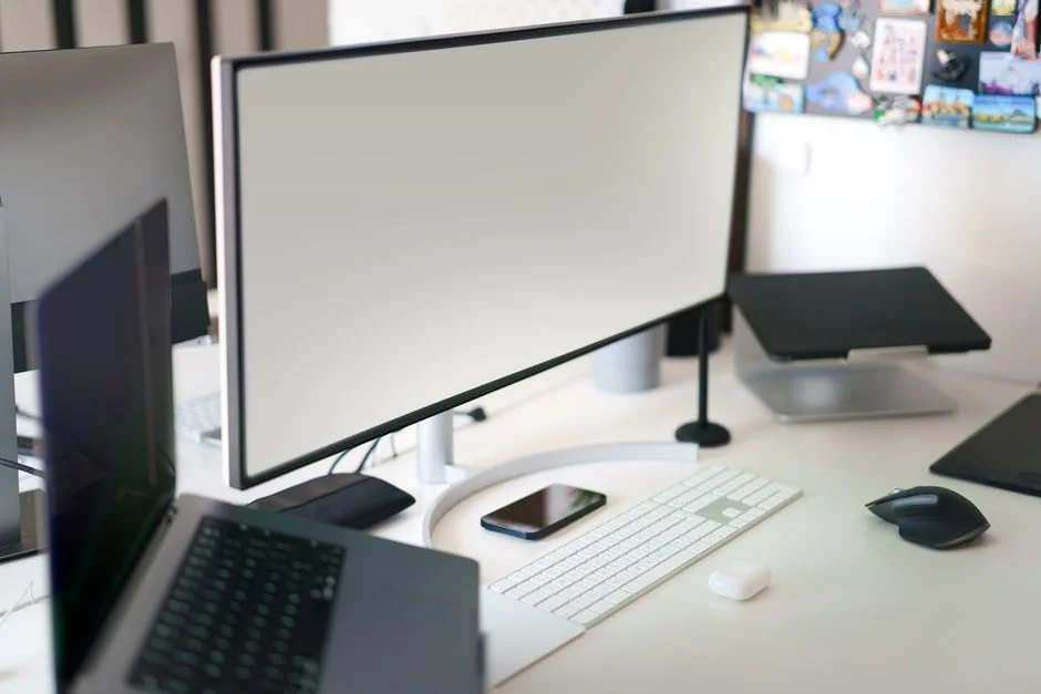 A sleek computer display showing web design work and creative visuals in a professional workspace.