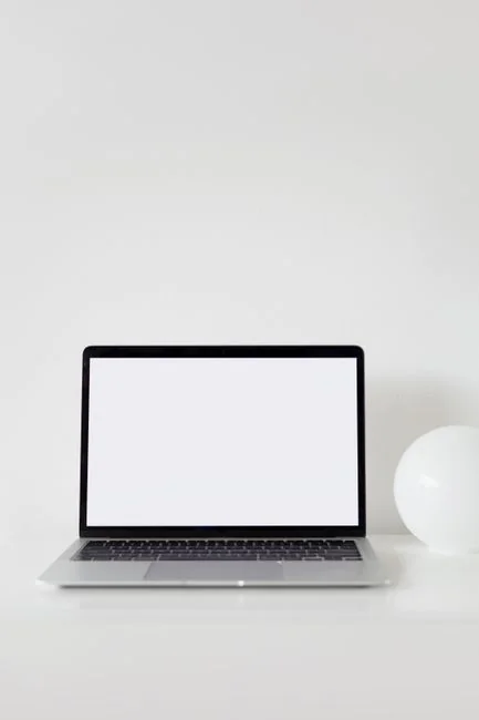Dual monitors on a desk, showcasing web design in a modern office setting.